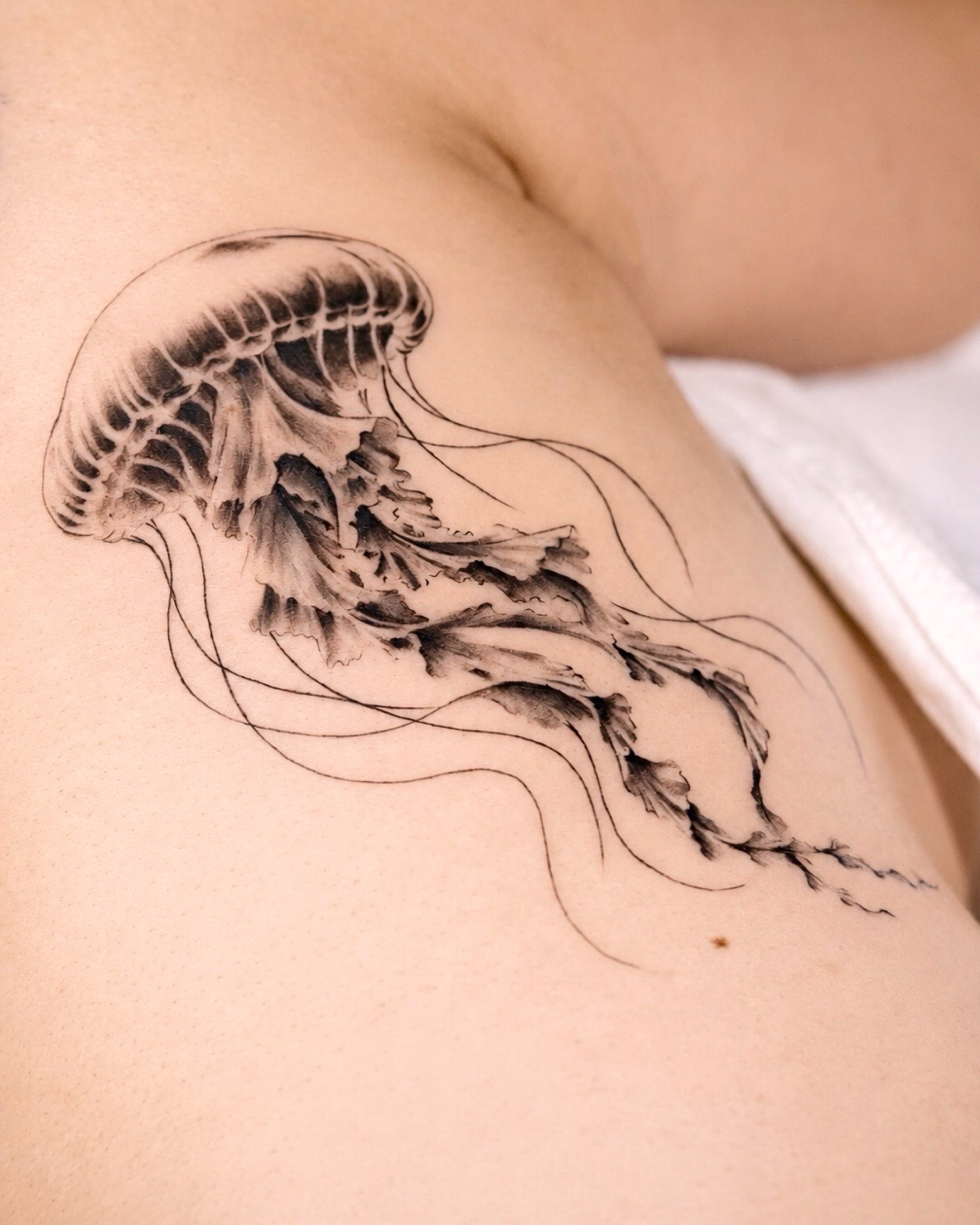 A jellyfish that flows on the body with soft shading, delicate lines & movement.… — tattoo by Vanessa Kee, Singapore, singapore
